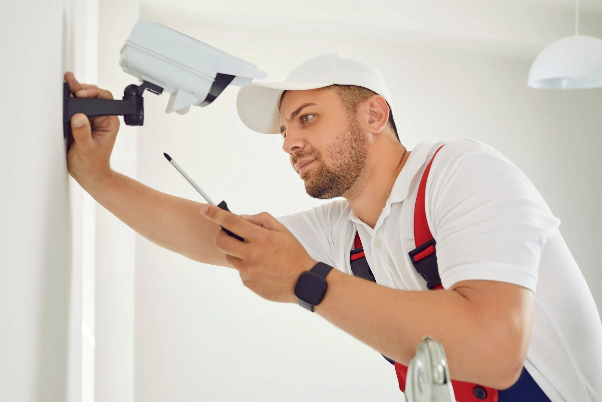 technician installer mounting CCTV equipment on an indoor wall